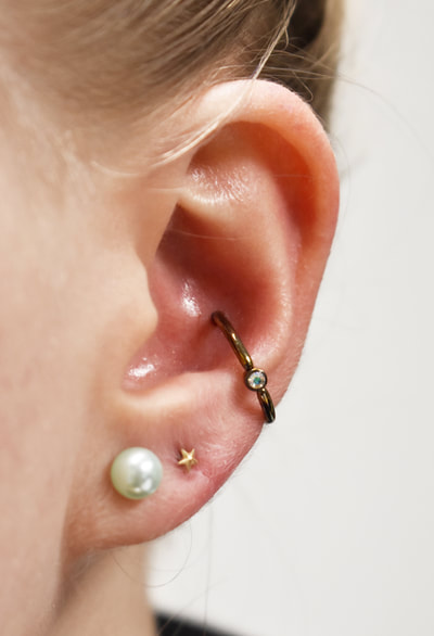 14 gauge anodized titanium captive bead ring with AB gem bead looking great in this fresh conch piercing!